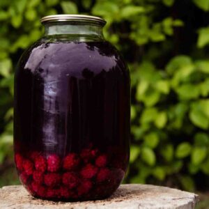 Canned raspberry compote in a glass jar